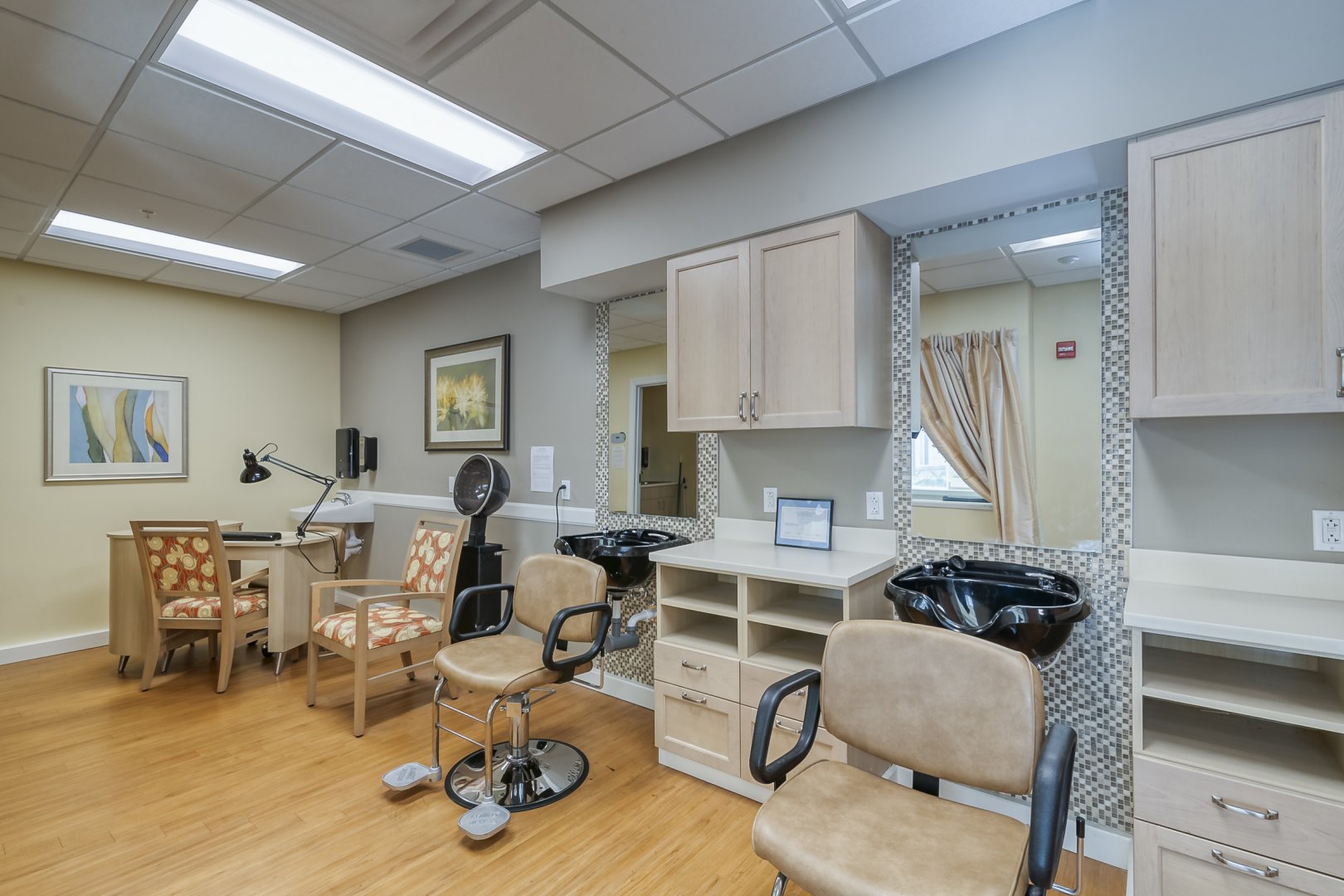 Modern salon interior with stylish chairs, hair washing stations, and nail stations in a bright room.
