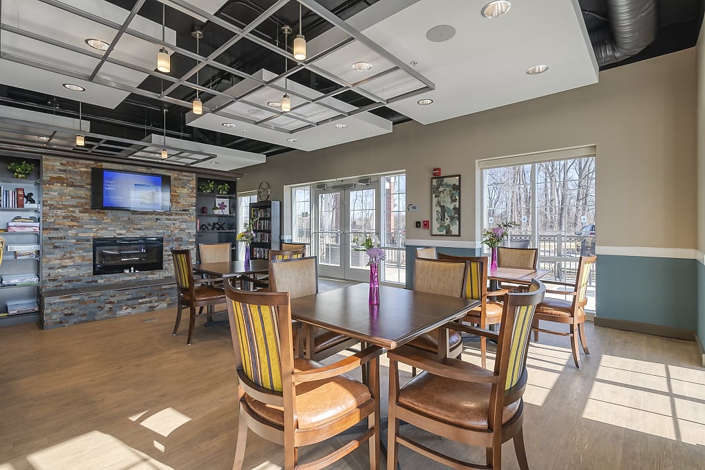 Common area with tables, chairs, a fireplace, and a TV.