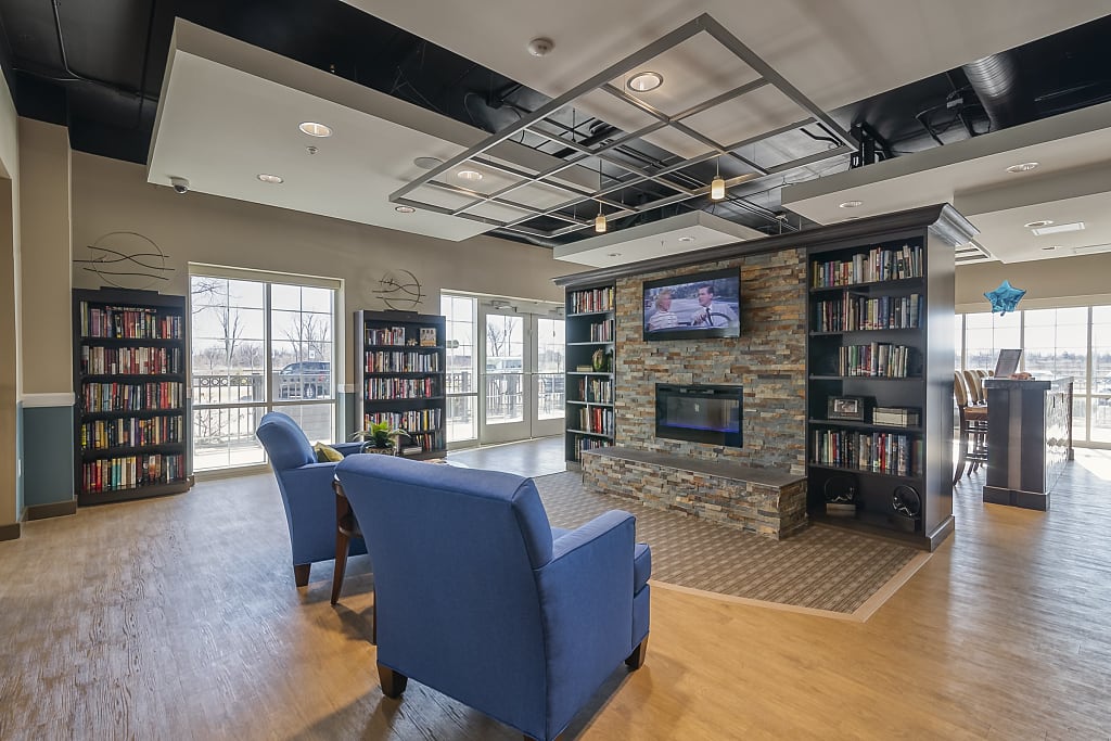 Common area with bookcases, fireplace, a TV, and two armchairs.