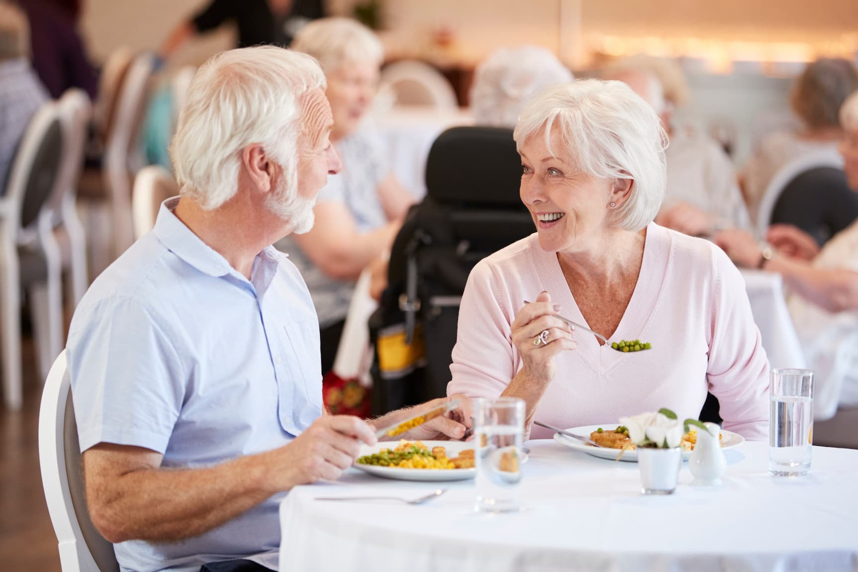 senior couple enjoying a meal at community dining room